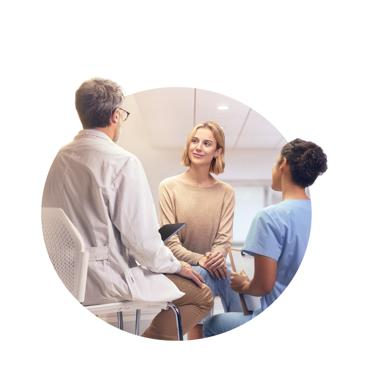 Photo image of an adult female patient speaking with doctor and nurse in a hospital setting